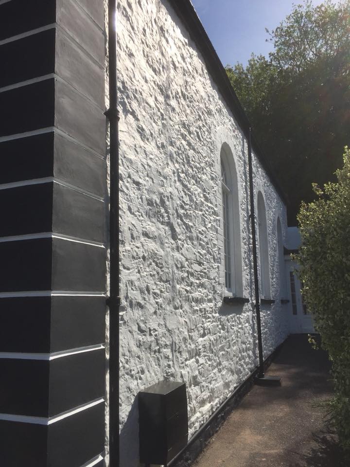 Black and white exterior of a chapel repainted and restored
