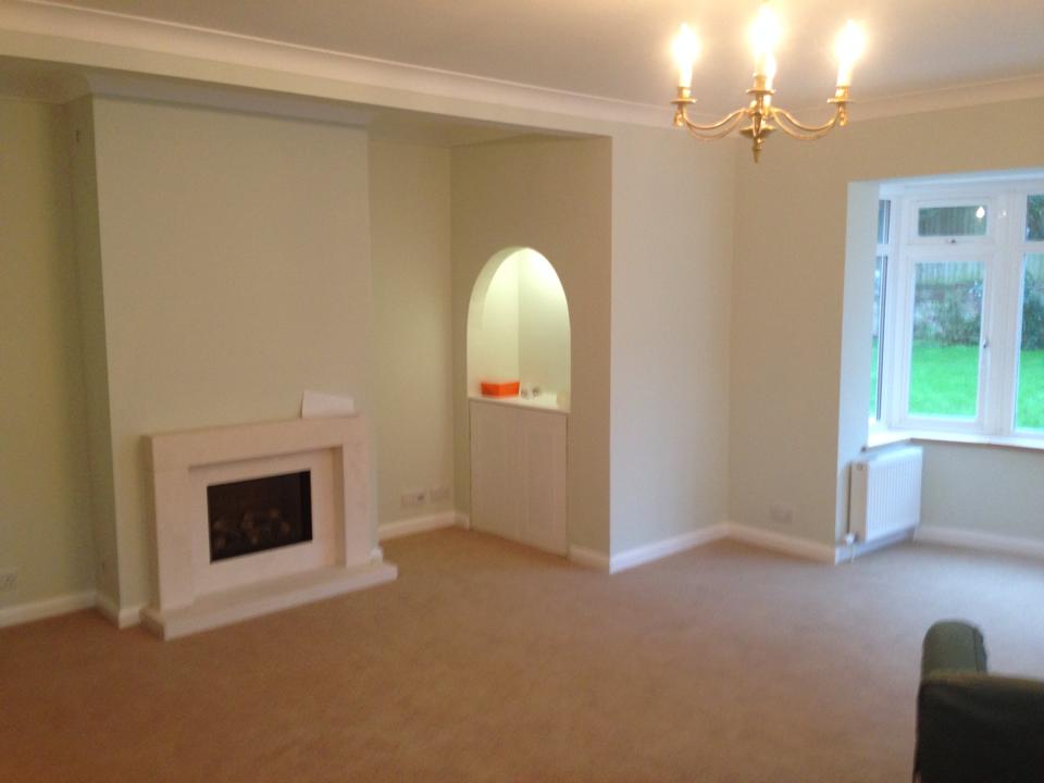 Living room painted in soft mint green with white fireplace